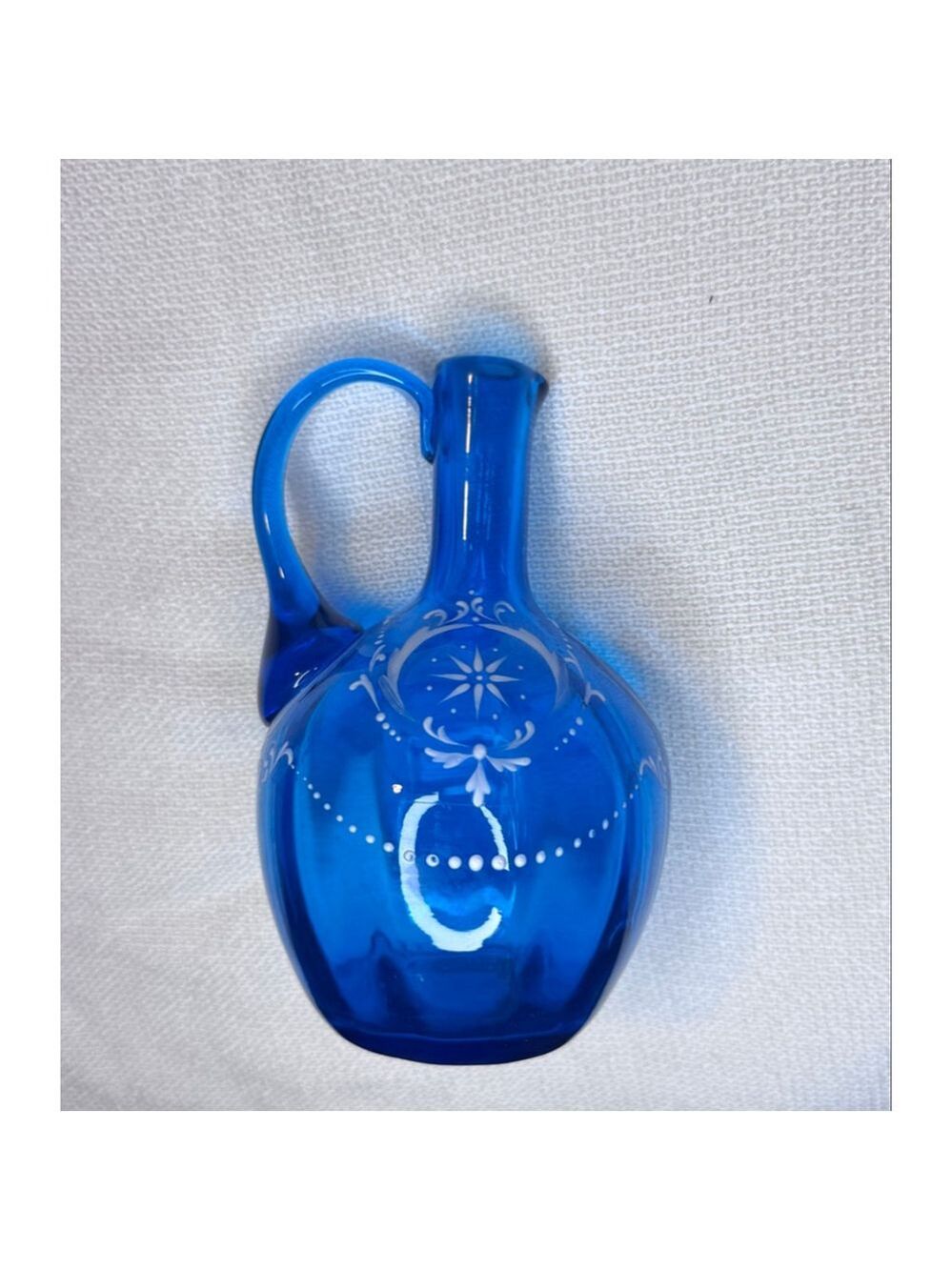 Vintage Blue glass decanter 6" spout and handle. White embossed